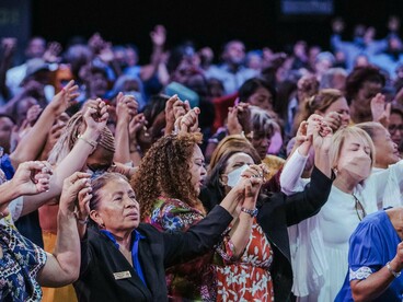 Fiéis participam de culto evangélico em momento de oração coletiva. A crescente aproximação entre religião e política tem redefinido discursos de poder e identidades sociais no mundo contemporâneo