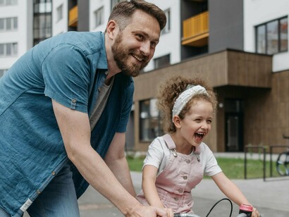 A joyful moment between a father and his daughter as they enjoy a carefree bike ride together, capturing the essence of spending quality time with loved ones, highlighting the importance of downtime and enjoyment in our lives