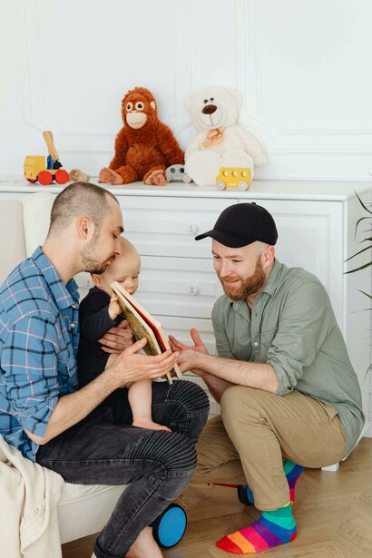 A gay couple playing with their child, reflecting queer creativity and family life