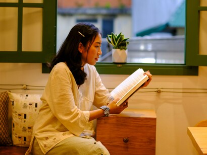 A woman relaxing with a book away from daily distractions, symbolizing the importance of protecting time for yourself