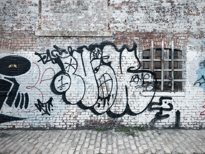 Un grafiti en forma de logo junto a una ventana