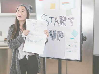 A young woman holding a graph while pitching her idea to investors