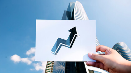 Goals and aspirations are represented on a perforated paper graph in front of a skyscraper, symbolizing the innovation ecosystem that drives economic growth 