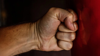 Mano che batte contro una superficie liscia rossa per rabbia