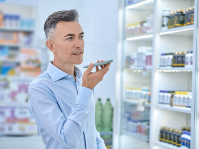 Inside a pharmacy, a man chooses medicines while a pharmacist provides guidance on supplements