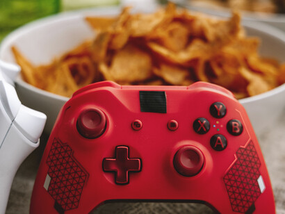 Controle de video-game próximo a balde de salgadinhos