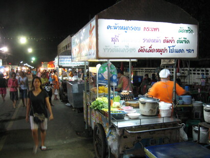 Los rasgos que definen la comida callejera son: pocos ingredientes, fácil preparación, no muy costoso y que pueda comerse en el momento mismo y con las manos.  Un carrito de comida en el mercado nocturno, Yasothon, Tailandia