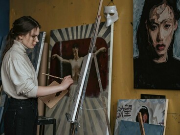 An artist immersed in the creative process, reflecting the careful visual composition that defines Satoshi Kon’s films