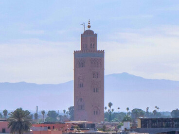 Le minaret veille sur Marrakech (Maroc), tandis que l’Atlas dessine l’horizon de la ville ocre