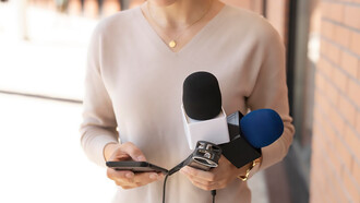 A woman holding a microphone, representing her role as a journalist or media personality
