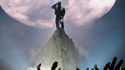 A masked Kanye West performs atop a mountain set at the Verizon Center in Washington, D.C., during The Yeezus Tour on November 21, 2013