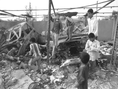 Niños de Nasiriyah juegan entre los cadáveres de autos, Irak