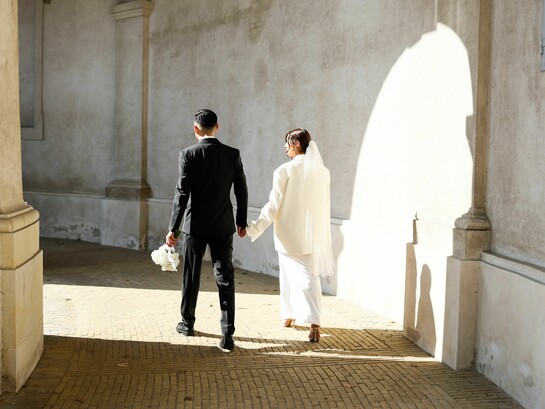 A newly married couple walking hand in hand into the light, representing the beginning of a lifelong partnership built on commitment
