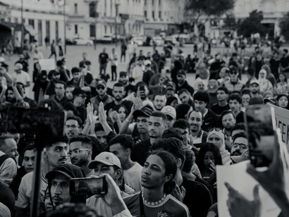A vibrant protest crowd filling a Moroccan city street
