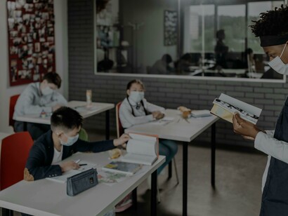 Um professor lendo um livro na frente da classe