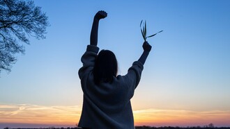 With arms raised in freedom and a sprig of life in hand, she embodies the power of simple, intentional choices to move, eat, and thrive toward a vibrant and healthy future