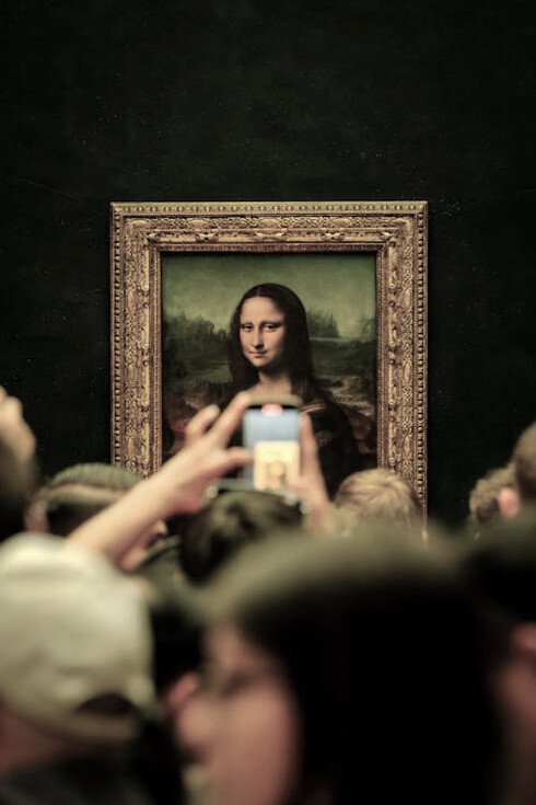 Crowds gather at the Louvre Museum in Paris, captivated by the famous Mona Lisa painting, France