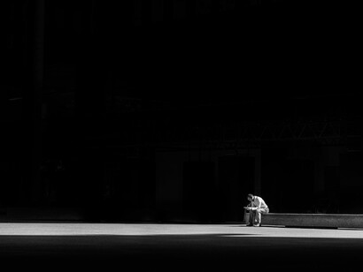 Persona seduta su un palcoscenico mentre legge un copione in totale solitudine  