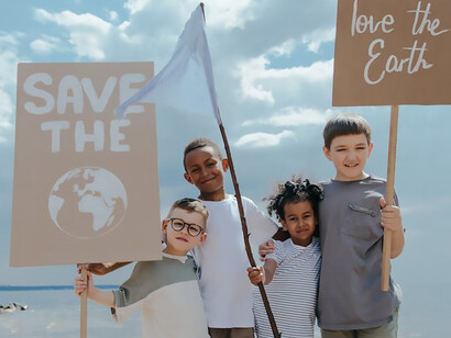Witness the passion of environmentally conscious children as they stand united against the climate crisis, proudly displaying banners that read "Save the World" and "Love the Earth"