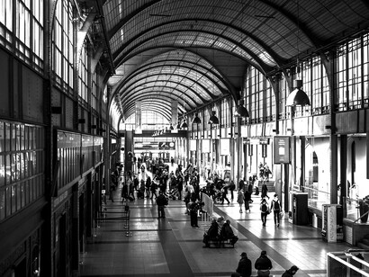 Blurry view of a busy train station with crowds moving through the space