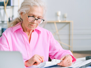 A senior citizen examining documents, symbolizing the growing concern over income security in later life