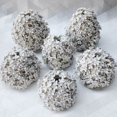 Basada en años de experiencia en cerámica, adopta un enfoque instintivo y visceral para cada pieza, esculpiendo minuciosamente cada pétalo y antera o brote a mano para que no haya dos flores idénticas