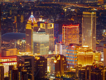 A vibrant skyline illuminated at night, representing the transformative potential of technology when guided toward collective prosperity