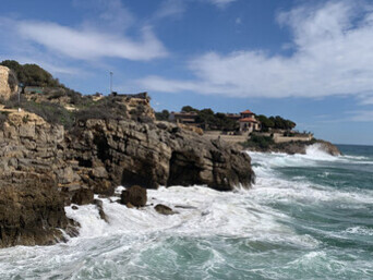 The Mediterranean clashes against the rocky cliffs of the city's coast