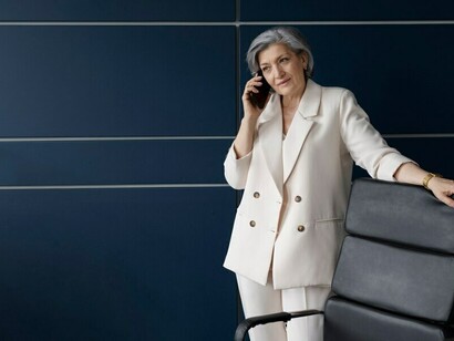 A senior woman engaged in her work at a desk in an office