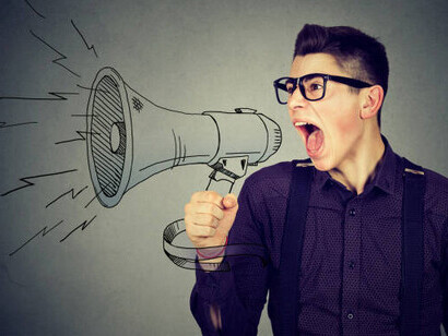 An angry young man screams into a megaphone, isolated, overwhelmed by political stress and constant news