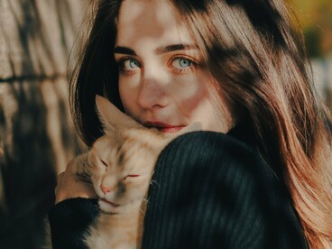 Mulher interage de perto com um gato, em uma cena que evidencia a relação de proximidade entre pessoa e animal. A imagem ajuda a visualizar o sentido literal de “gata”, antes que o texto explore sua transformação em uma expressão de sentido figurado