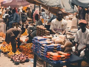 A bustling market filled with vendors, produce and essential goods, reflecting the resilience of local livelihoods amid economic pressures