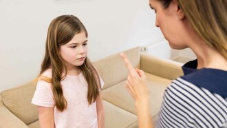 An upset mother raising her finger at her worried child trying to be a parent but probably coming off as an authoritarian