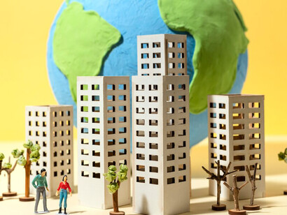 A paper-style globe features miniature paper buildings, creating a delicate representation of Earth