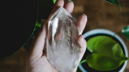 Mão segurando um cristal. 
Como um encontro de almas, saudando a cura e a beleza, os olhos brilham ao sentir a pluralidade dos cristais