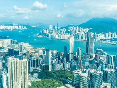 An aerial view of Victoria Harbour in Hong Kong, symbolising the city’s harmony between nature and towering architecture
