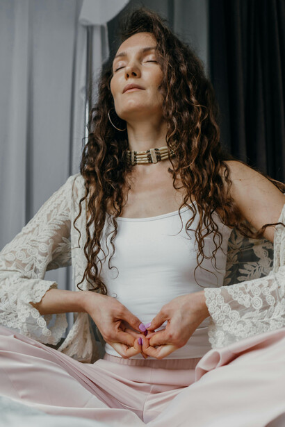 A peaceful woman meditates at home in a quiet indoor space, reflecting a mindful and calming morning ritual