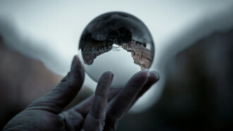 A hand cradling the world, representing care for global issues and environmental stewardship