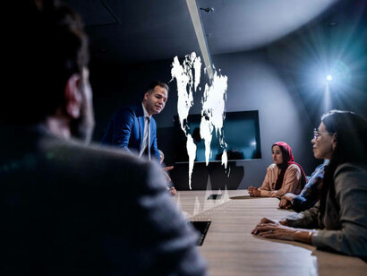 A man presenting a hologram during a meeting at the office, exploring global challenges and solutions through global collaboration