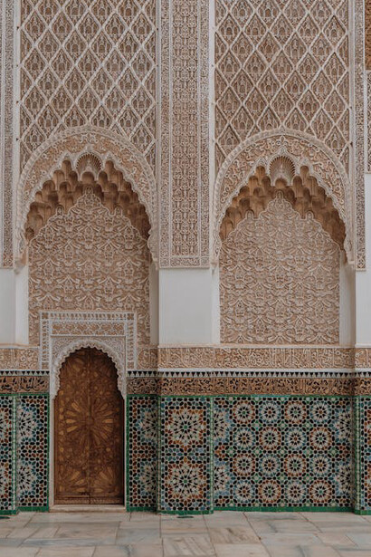 An arched door in a building in Marrakesh, Morocco, adorning the beauty of Zellij that covers historical monuments and palaces all over Morocco
