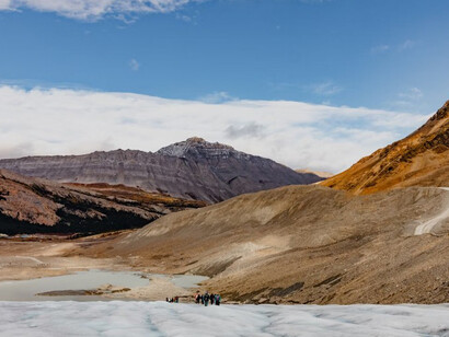 A group of individuals standing on a snow-covered slope, witnessing the effects of global warming as glaciers melt around them