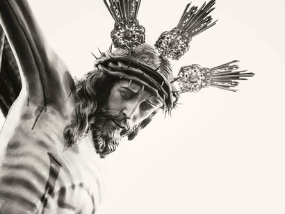 Black-and-white photograph capturing the solemn beauty of a crucifix of Jesus in Carmona, Andalusia, Spain