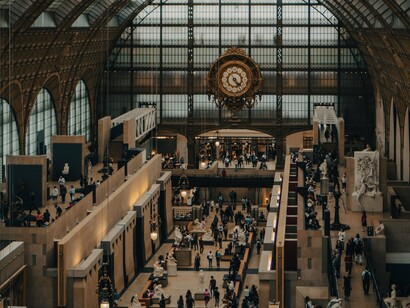 The monumental clock at Musée d'Orsay, Paris, France, watching over the museum's crowds, symbolising time as the invisible currency of modern society