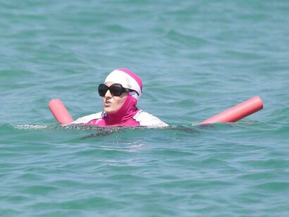 Mulher tomando banho com burkini