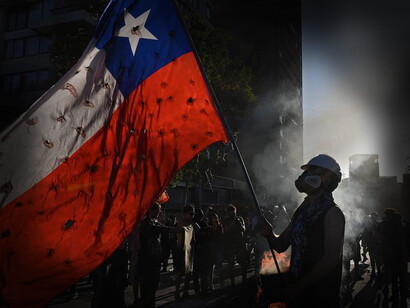 Hombre sujeta una bandera de Chile durante una protesta en el año 2019