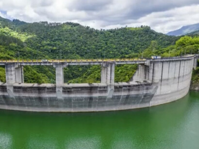 La ciudad se electrifica… pero el sistema que la alimenta sigue, en gran parte, oliendo a fósil. Esa es la paradoja que me interesa mirar en este texto.  Rio Nizau, presa Jiguey, San José de Ocoa, República Dominicana