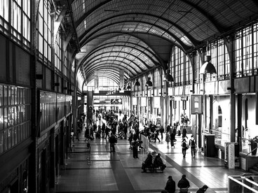 Blurry view of a busy train station with crowds moving through the space