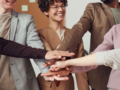 Colleagues assemble as a team by putting their hands together after a successful display of teamwork