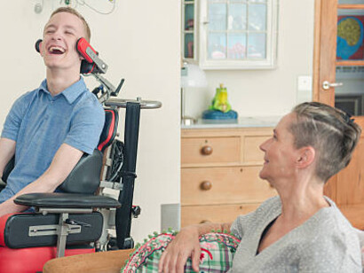 A mother helps her son living with amyotrophic lateral sclerosis (ALS)