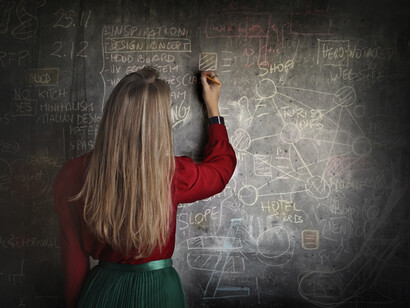 Mujer joven escribiendo fórmulas matemáticas en un pizarrón